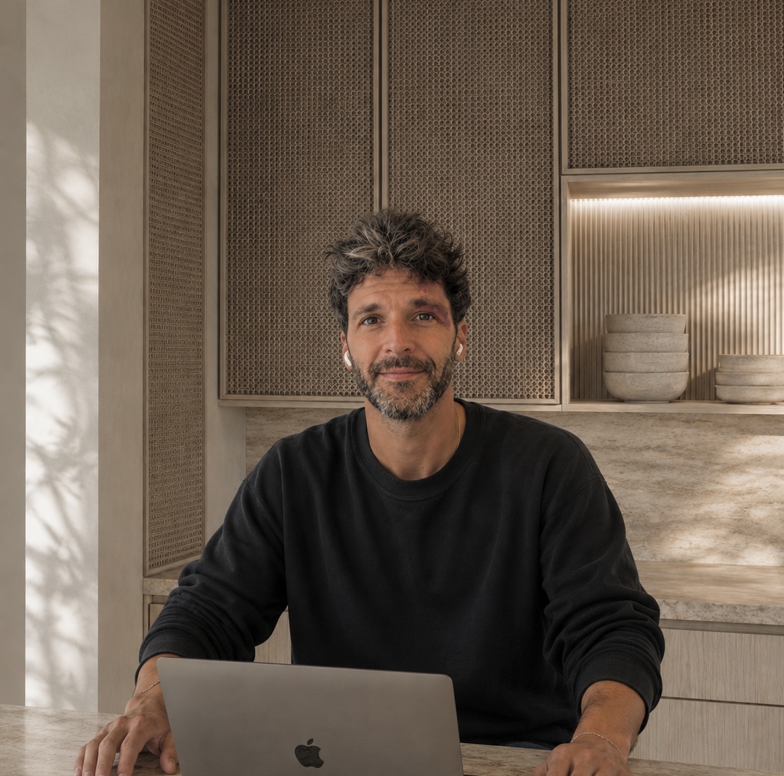 Xabier Cabello, product designer, trabajando con un portátil en un interior de madera y piedra